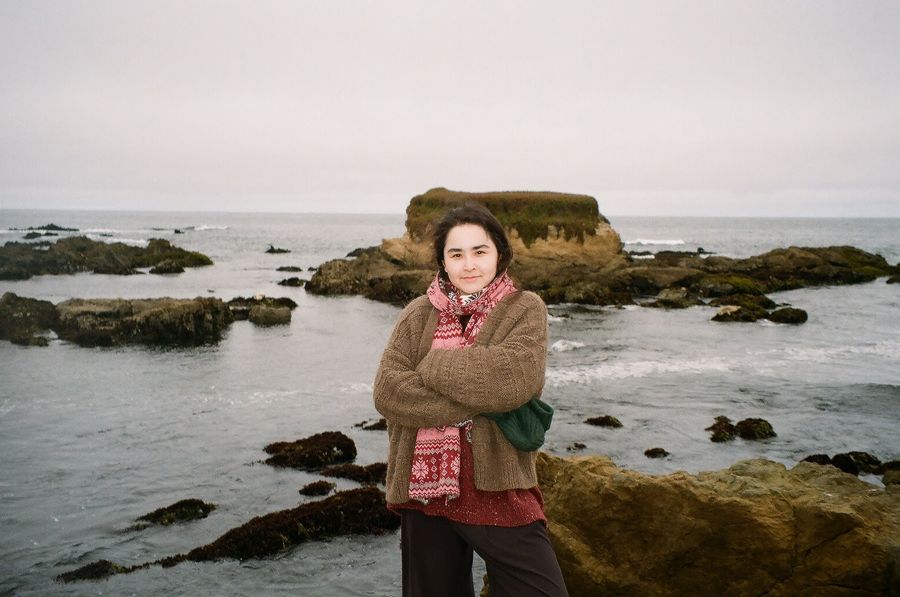 Dana in a hand-knit cardigan by the winter sea